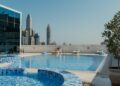 A woman relaxes at the edge of one of Dubai's most stunning luxury pools with the city skyline behind her