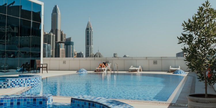 A woman relaxes at the edge of one of Dubai's most stunning luxury pools with the city skyline behind her