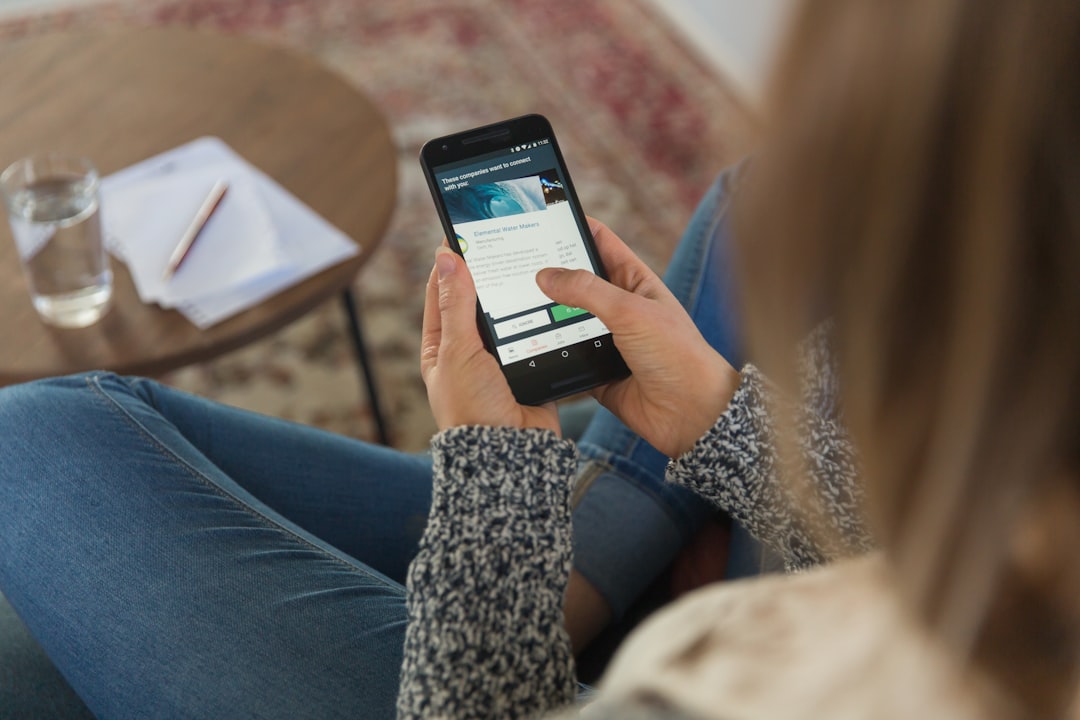 A woman using the DEWA smart app on her phone to monitor energy usage and manage her cool home this summer