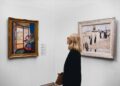 woman-viewing-gallery-painting-unsplash - DUBAIwebzine A visitor stands before a large canvas inside one of Dubai's air-conditioned art galleries during summer