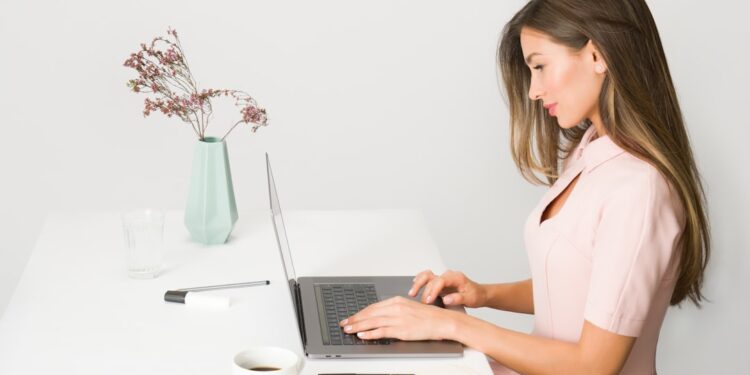 woman-working-laptop-office-unsplash - DUBAIwebzine A female entrepreneur builds her personal brand strategy during Dubai's low season at a modern co-working space