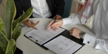 A business lawyer reviewing a commercial contract in a Dubai office, DIFC Courts support dispute resolution for investors