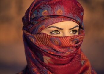 A performer delivers a monologue during an Arabic theatre production in Dubai, spotlighted on a small indoor stage.