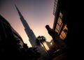 A Dubai investor reviewing a private equity deal agreement at a financial centre office