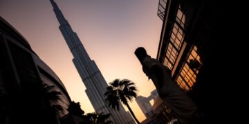 A Dubai investor reviewing a private equity deal agreement at a financial centre office