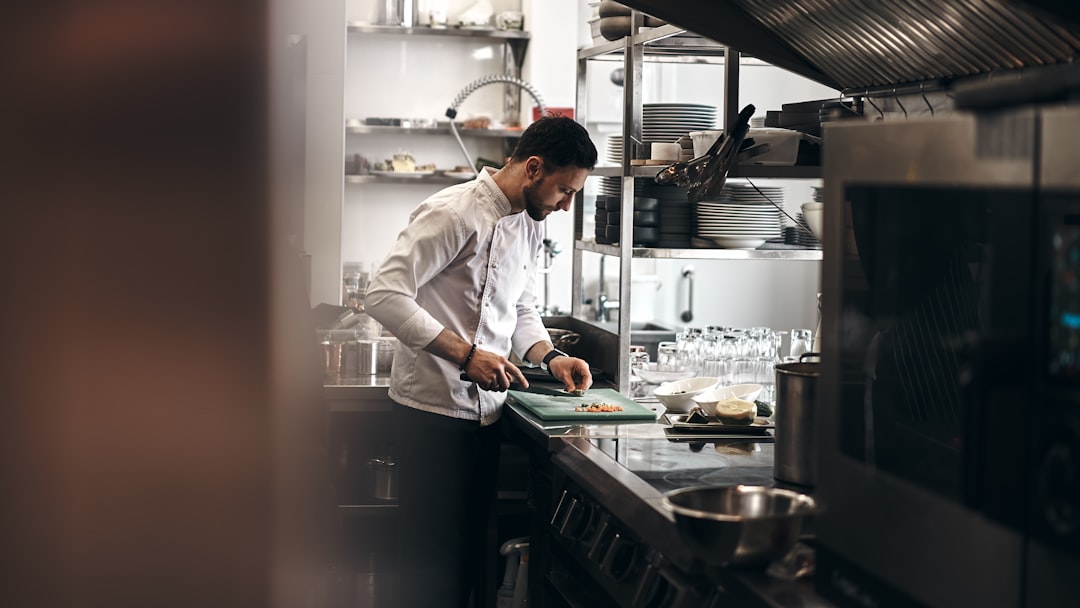 A hotel chef plating a separate gluten-free buffet dish for a guest with dietary needs in Dubai