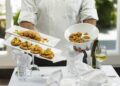 A chef presents a beautifully plated seasonal dish to diners at a Dubai restaurant launching its autumn menus