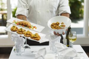 A chef presents a beautifully plated seasonal dish to diners at a Dubai restaurant launching its autumn menus