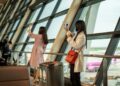 A traveler checking a boarding pass at a Dubai departure gate before flying one of the expanded Emirates routes