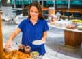 A woman carefully reading allergen labels at a gluten-free buffet spread in a Dubai hotel restaurant
