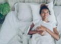 A woman opening curtains to morning sunlight as part of her sleep schedule reset in Dubai