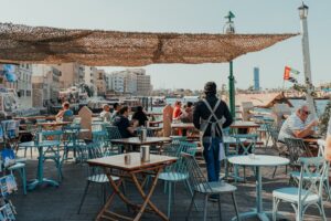 Two women enjoying coffee at an outdoor cafe as part of their social life in Dubai after summer