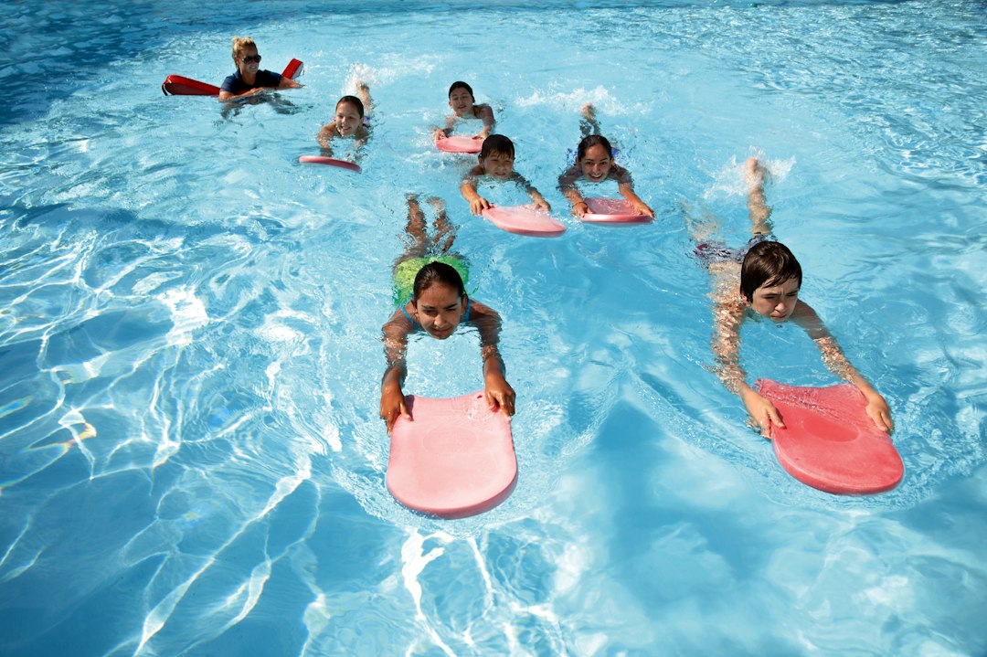 A swim coach guiding a child through after-school programmes in a Dubai pool