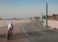 A family cycling along a beachside track in Dubai, enjoying outdoor activities together in the early morning light