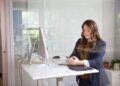 professional-woman-office-unsplash - DUBAIwebzine A focused entrepreneur reviews her Dubai business registration documents at a modern office desk in the UAE