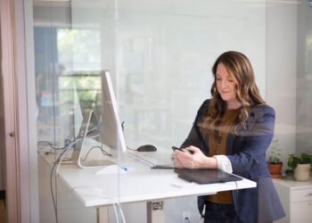 professional-woman-office-unsplash - DUBAIwebzine A focused entrepreneur reviews her Dubai business registration documents at a modern office desk in the UAE
