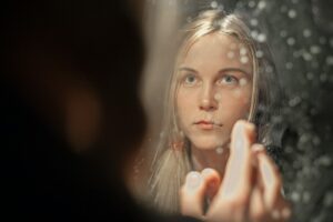 A woman applying a rich moisturizer as part of her updated skincare regimen during Dubai's seasonal humidity drop