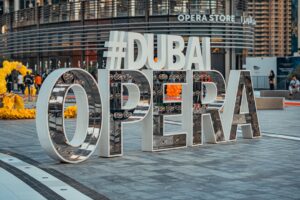 A visitor studying the Dubai cultural calendar programme outside Dubai Opera before an evening performance