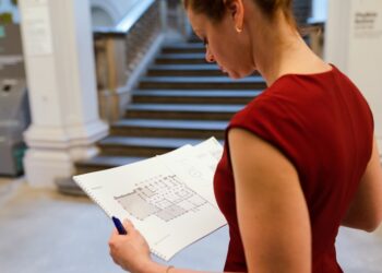 A professional investor reviews Dubai property market data and transaction reports at her desk