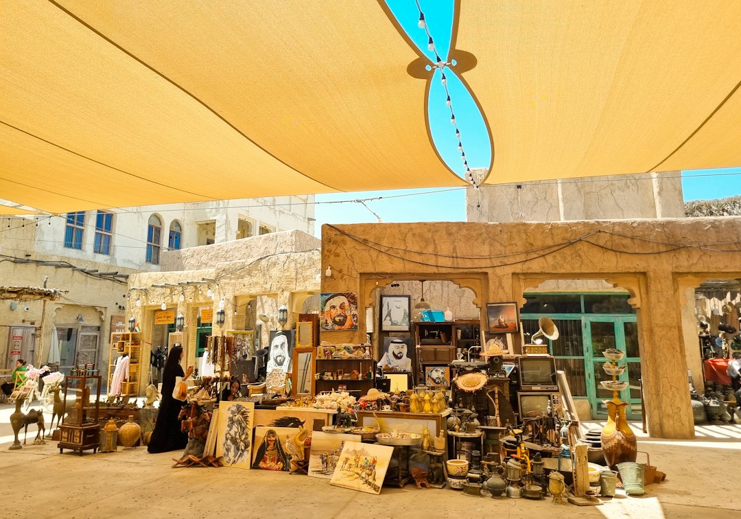 Woman walking past wind towers near the Sikka festival district in Al Fahidi