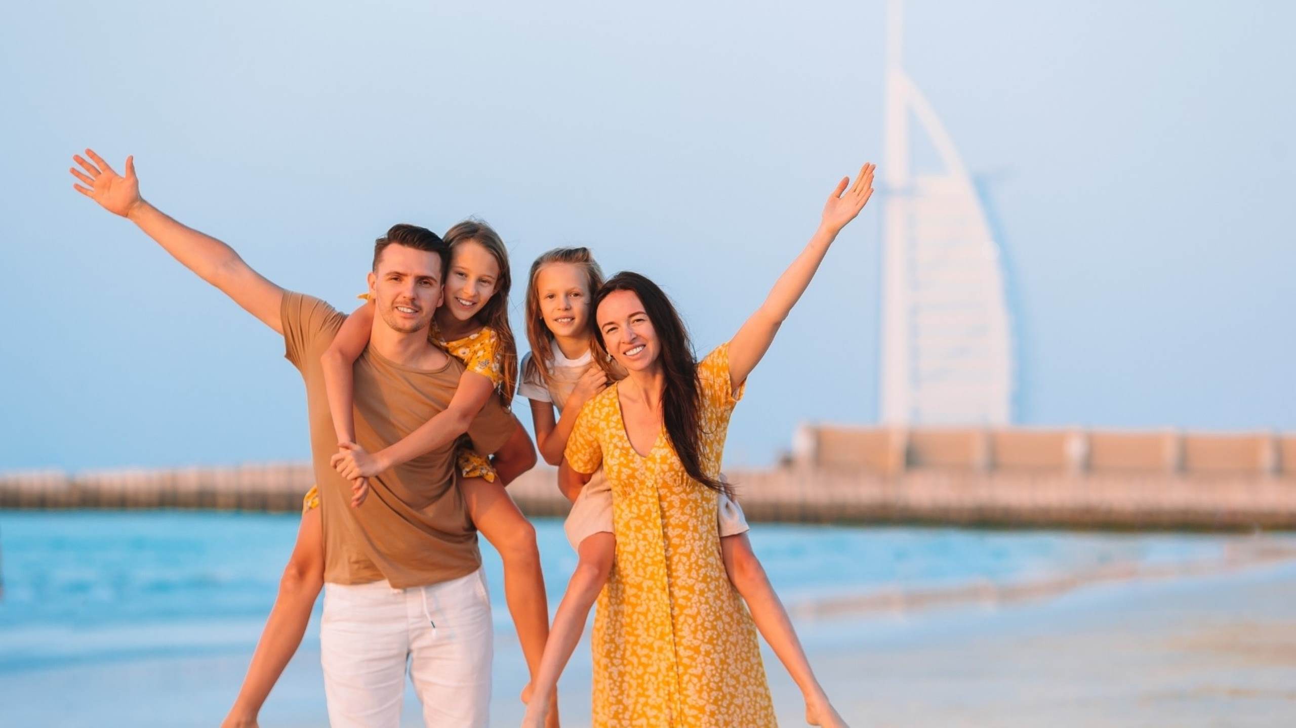 Famille avec enfants sur la plage avec le Burj Al Arab Dubaï, enfants confiants, parentalité résiliente, émotionnellement consciente