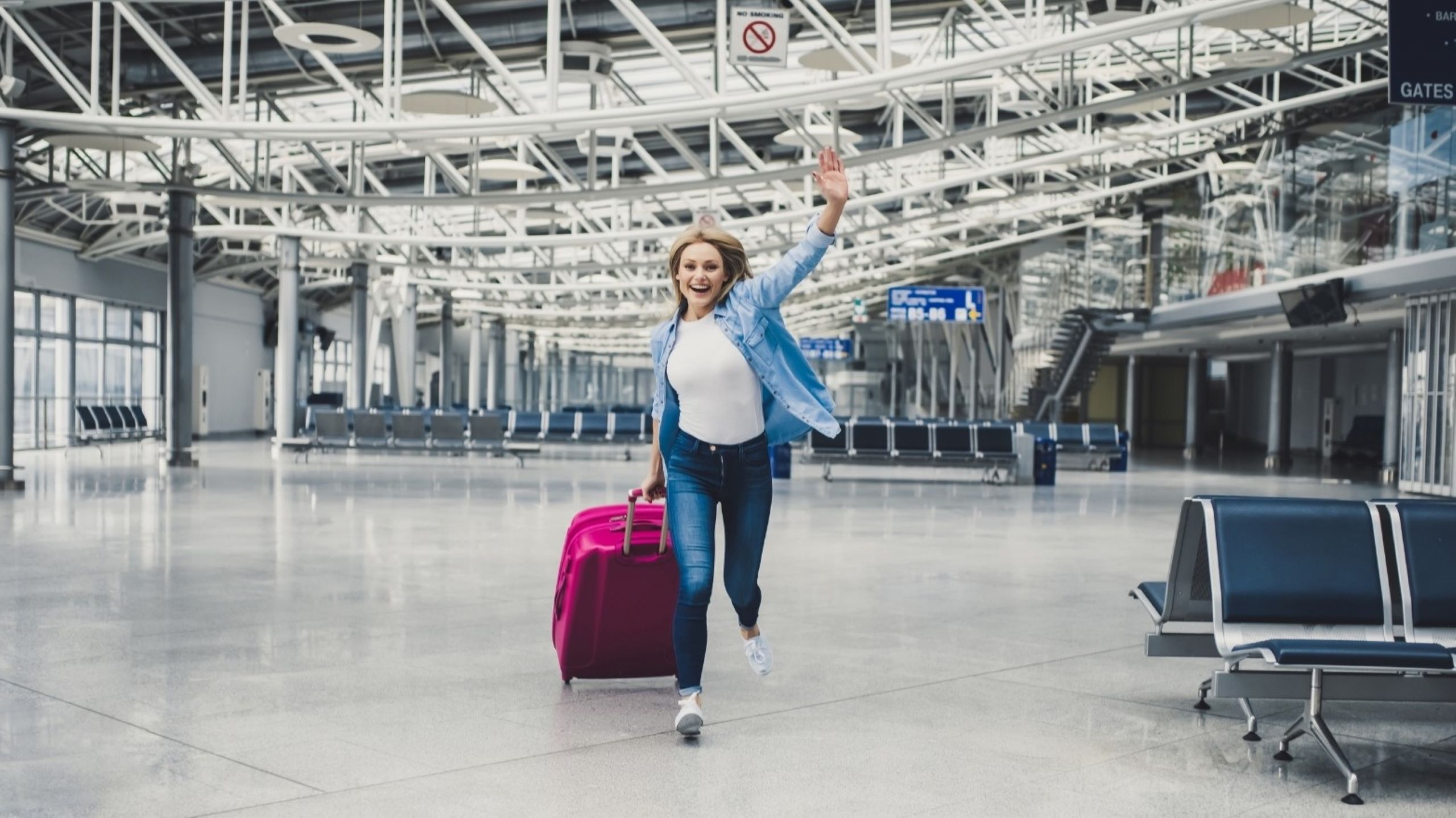Viajero con maleta en la puerta de salida del aeropuerto de Dubái, escapadas de fin de semana, vuelos y viajes de aventura