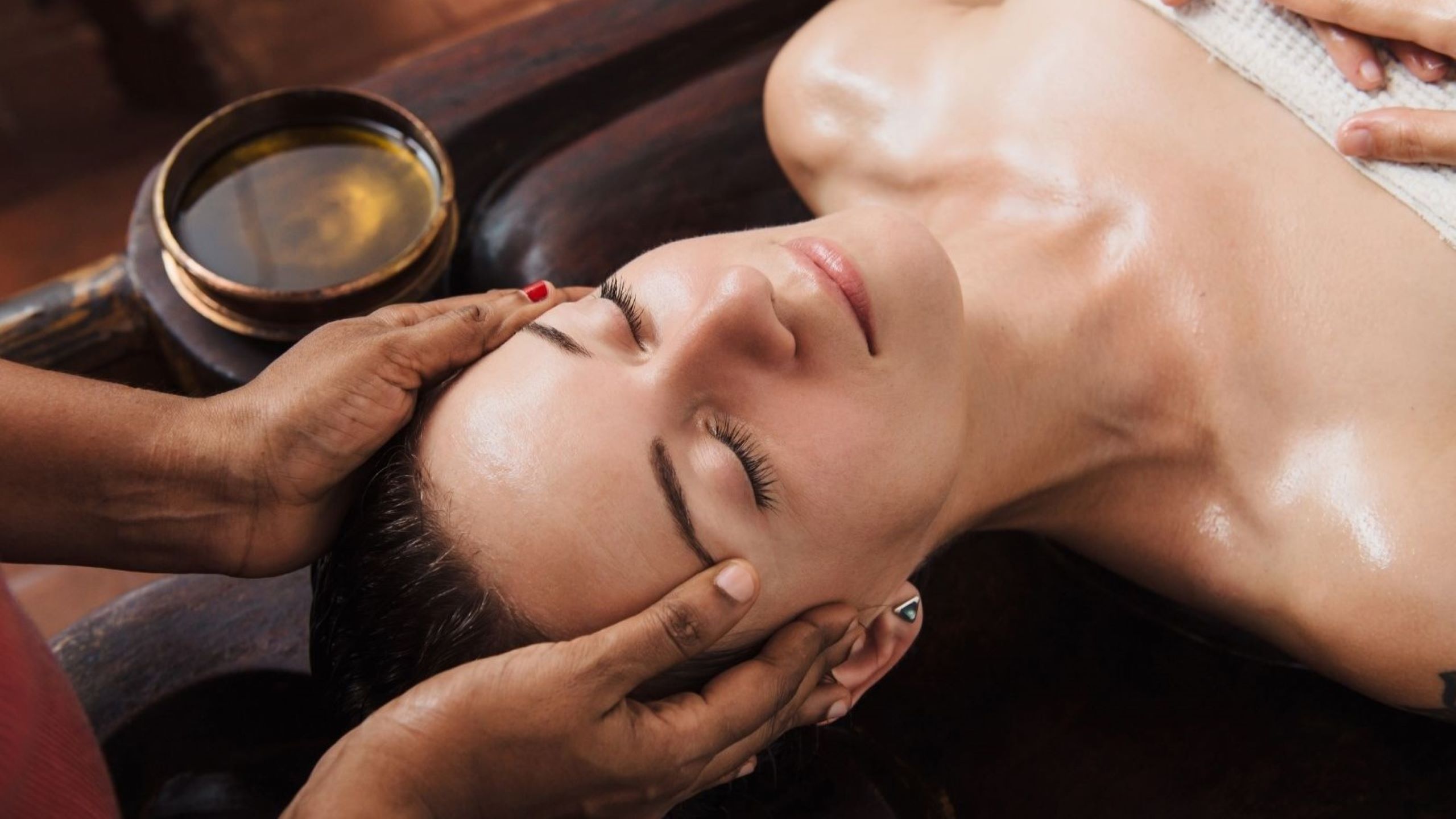 Femme recevant un soin du visage ayurvédique aux huiles essentielles dans un spa de luxe Rituels de beauté ayurvédiques éclat holistique et radieux