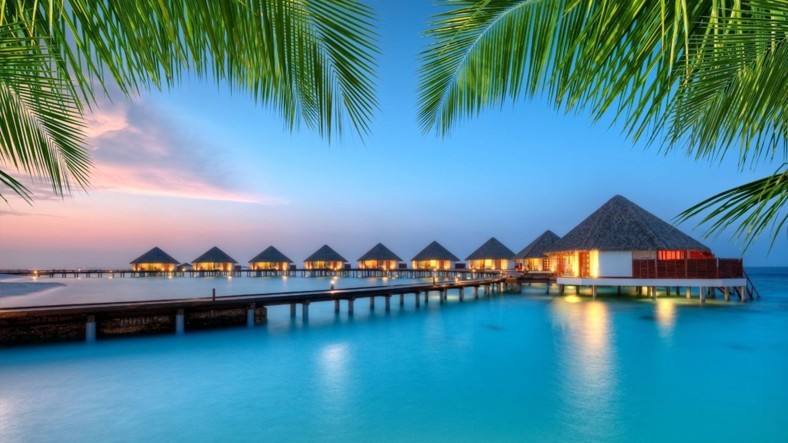 Lussuoso resort sulla spiaggia delle Maldive con fuochi d'artificio di Capodanno sull'oceano, che rappresenta la perfetta fuga tropicale da Dubai per le celebrazioni 2025-2026 con spiagge incontaminate ed esperienze di paradiso insulare
