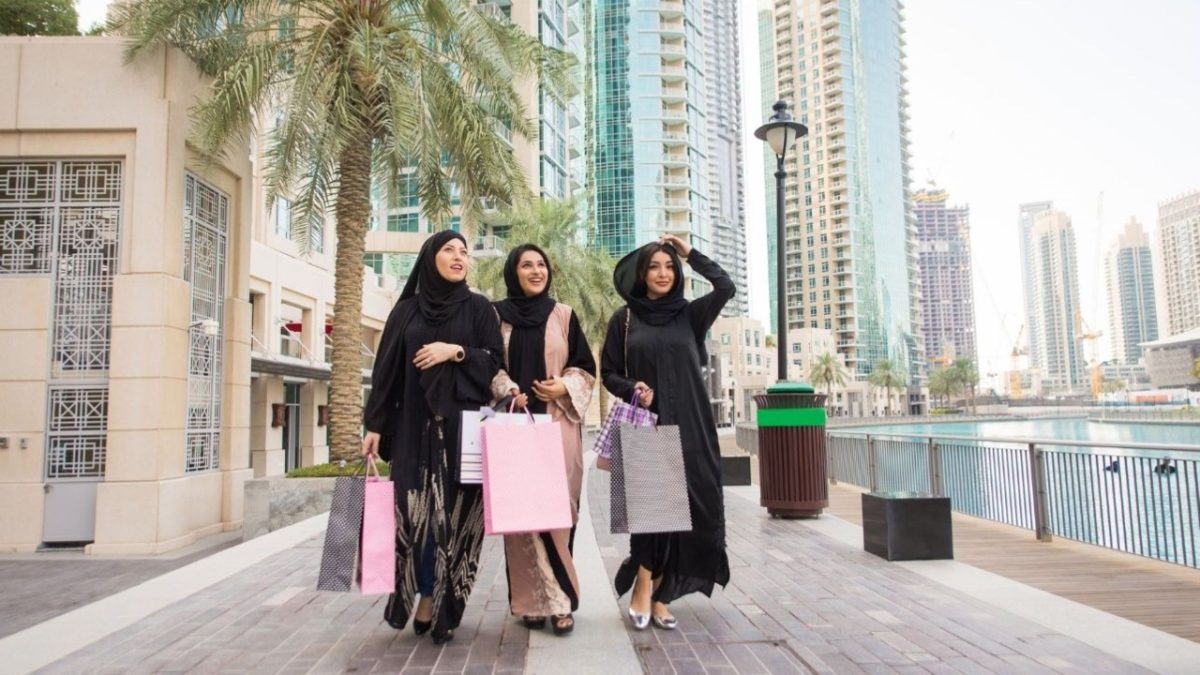 des femmes explorant les offres à l'intérieur d'un centre commercial de Dubaï pendant Dubai Summer Surprises, entourées de promotions festives colorées.