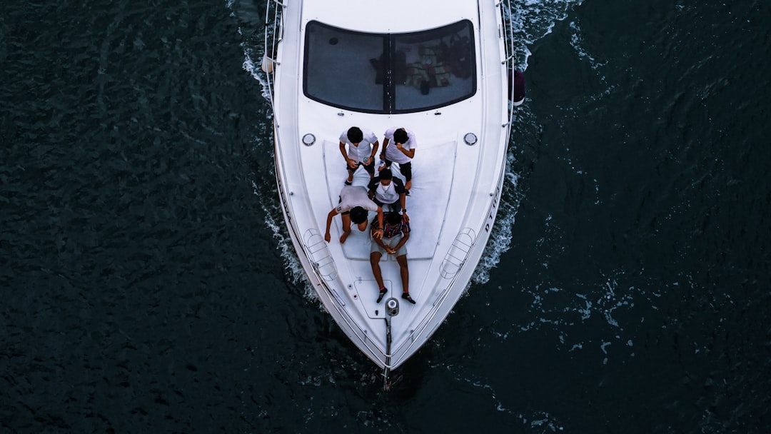 amigos disfrutando de un alquiler de yate privado en Dubái con el horizonte de la ciudad visible al otro lado del agua