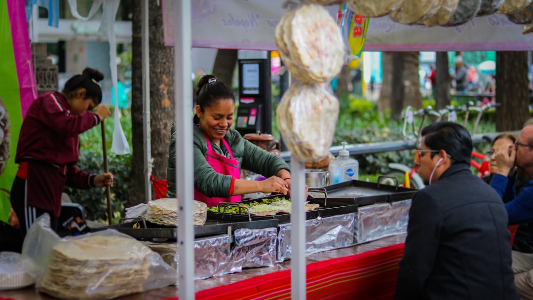 Un vendeur enveloppe soigneusement un shawarma frais à un étal de restauration rapide animé dans une ruelle de Dubaï la nuit