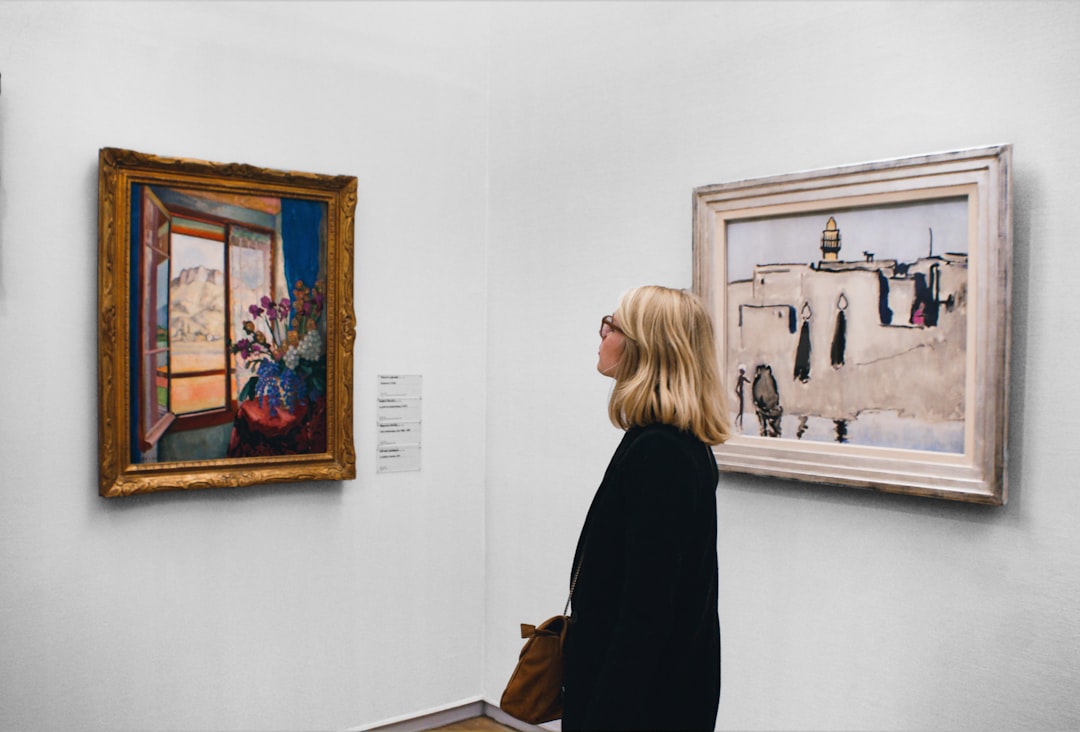 Un visitatore si ferma davanti a una grande tela all'interno di una delle gallerie d'arte climatizzate di Dubai durante l'estate