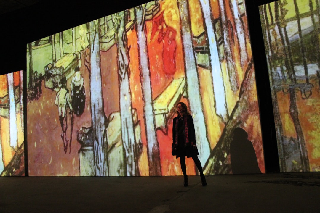 Une femme traverse une salle de projection numérique lumineuse lors d'une expérience d'art immersif dans un centre commercial de Dubaï