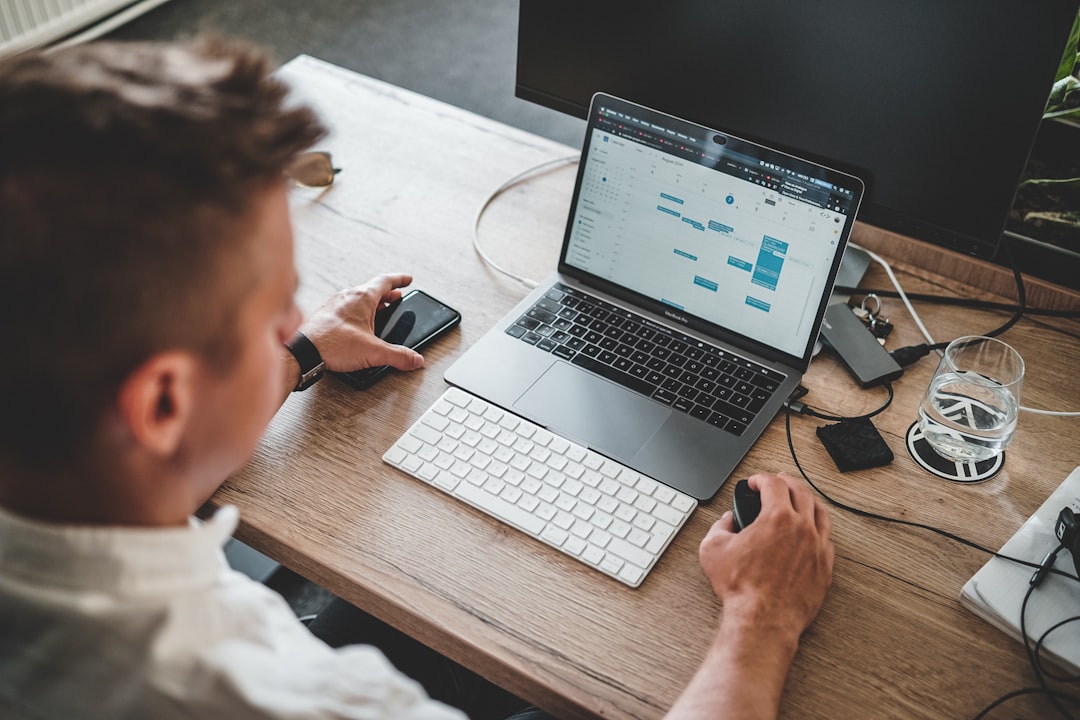 Un professionnel concentré à la recherche de clients en freelance sur un ordinateur portable dans un espace de coworking moderne à Dubaï