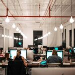 Un fondateur de startup concentré travaillant à un bureau dans l'un des meilleurs espaces de coworking de Dubaï, avec un horizon urbain visible.