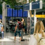 Une voyageuse souriante vérifie sa carte d'embarquement à une porte d'embarquement de l'aéroport de Dubaï, en attendant son vol en correspondance.