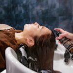 Une femme appliquant un masque de conditionnement profond pour réparer les cheveux endommagés par la chaleur à domicile à Dubaï