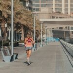 Une femme s'étirant sur un sentier extérieur ombragé dans le cadre de sa routine matinale aux premières heures de Dubaï