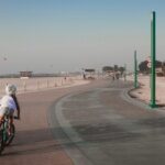 Une famille fait du vélo le long d'une piste en bord de mer à Dubaï, profitant ensemble des activités de plein air sous la lumière du petit matin