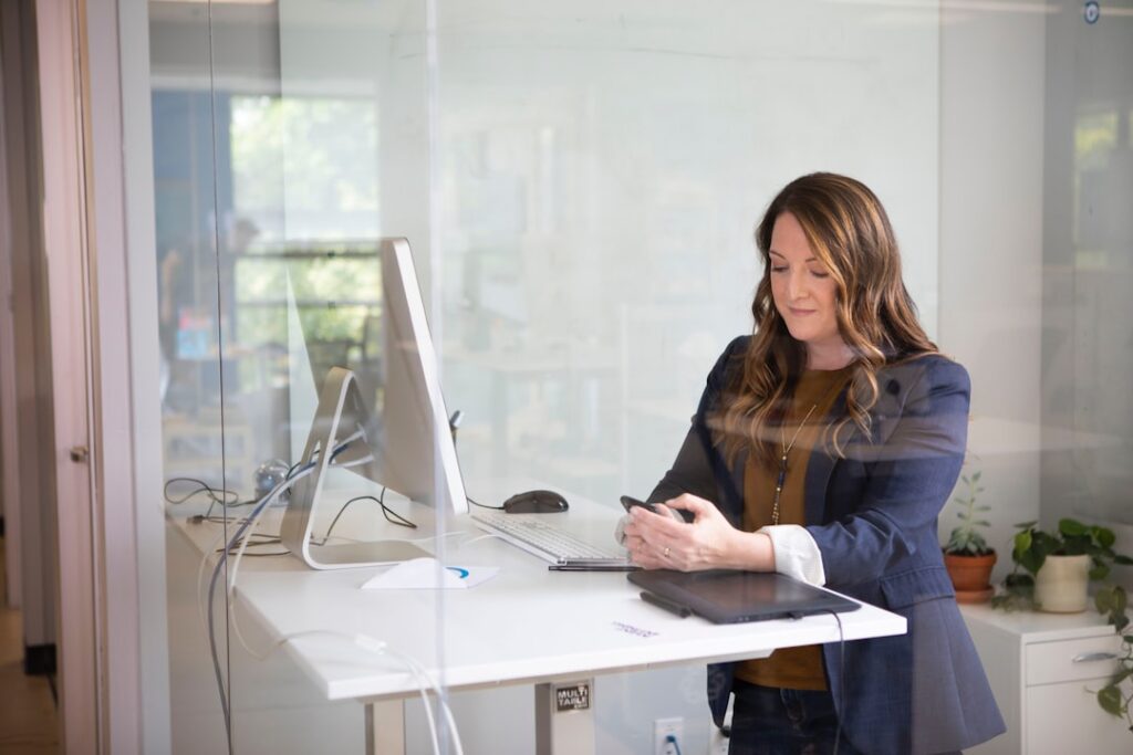 Une entrepreneuse concentrée examine ses documents d'enregistrement d'entreprise à Dubaï sur un bureau moderne aux EAU
