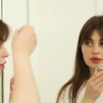 Une femme applique un soin hydratant riche dans une salle de bain lumineuse dans le cadre de sa routine de soins de la peau d'automne à Dubaï