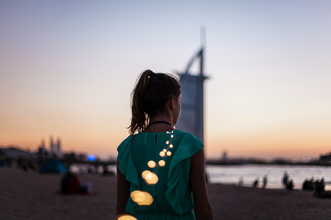 Uma mulher vestida para uma noite fora em frente à Dubai Opera, pronta para aproveitar o calendário cultural de Dubai neste outono