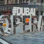 Un visiteur étudiant le programme du calendrier culturel de Dubaï devant le Dubai Opera avant une représentation en soirée