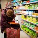 Une femme choisissant des produits en vrac dans un supermarché de Dubaï, réduisant sa consommation de plastique avec un sac de courses réutilisable en filet