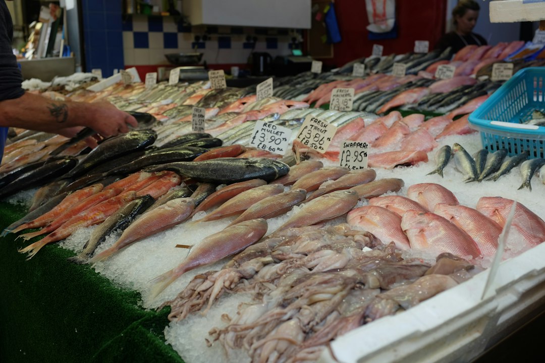 Comprador seleccionando hammour en un puesto del mercado de mariscos de Dubái
